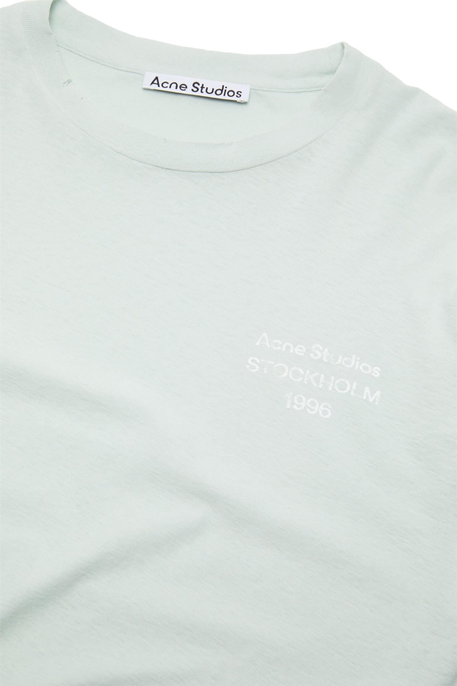 Acne mintfarget logo T-skjorte med distress-effekt, bomulls-genser med avslappet passform og grafisk design.