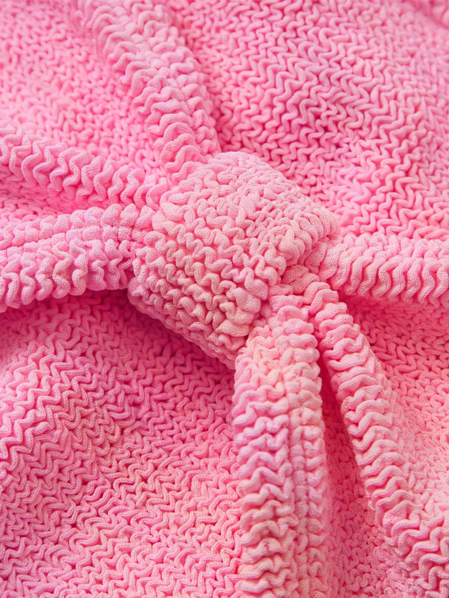 Hunza G Jean bikini i rosa, bubblegumfarget, laget av glatt, stretchig stoff, vist i en livlig strandscene