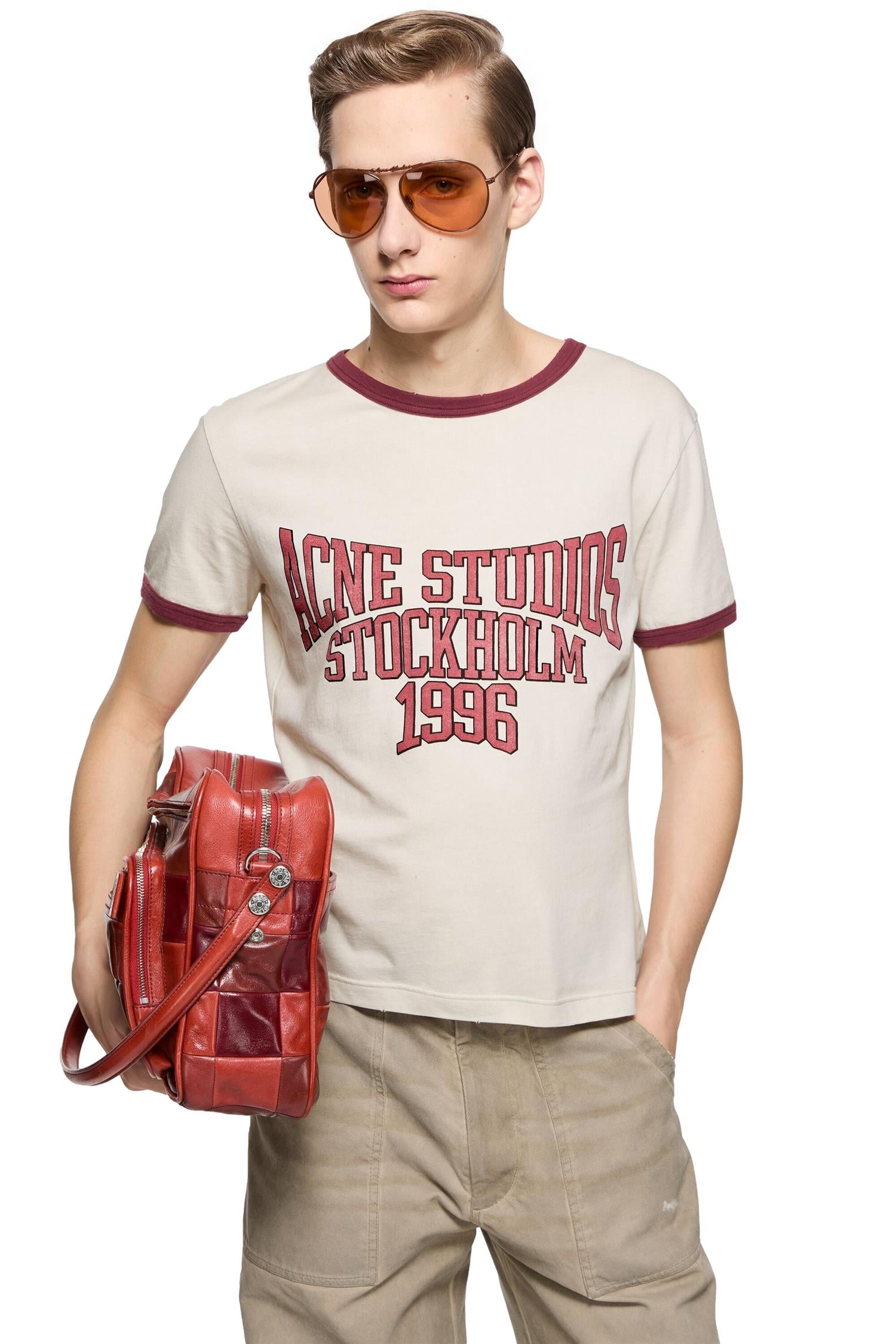 Beige og rød Acne T-skjorte med grafisk design, vist på en modell, komfortabel og stilfull passform.