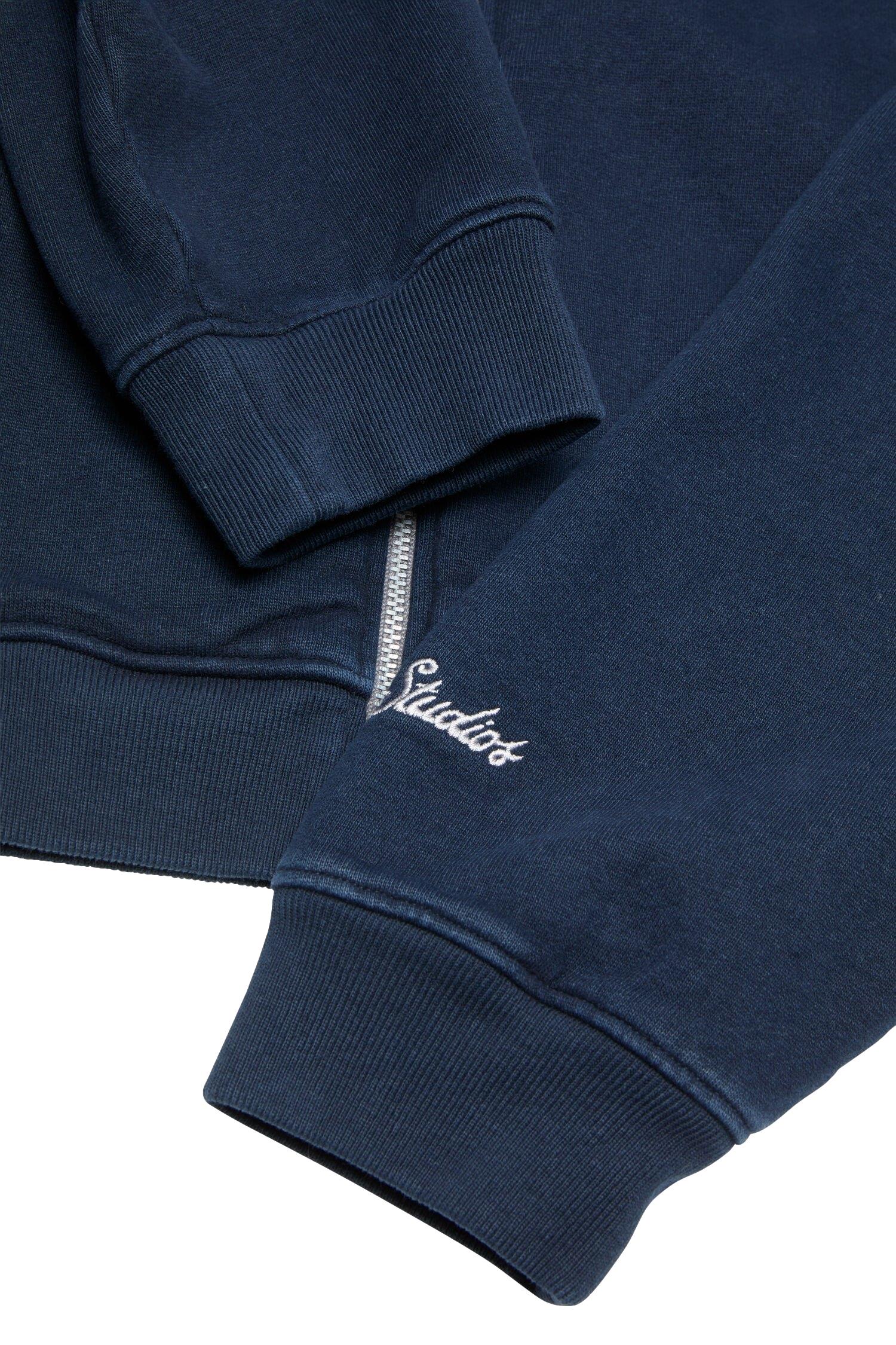 Mørkeblå Acne zip-up sweatshirt jakke med glidelås og casual passform, vist på modell.