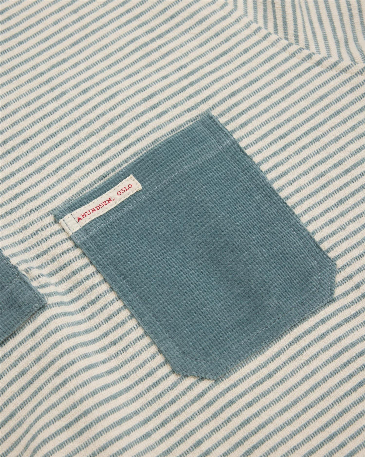 Amundsen dames genser i stormy blue med hvite og turkise detaljer, myk og komfortabel chukka-stil pullover.