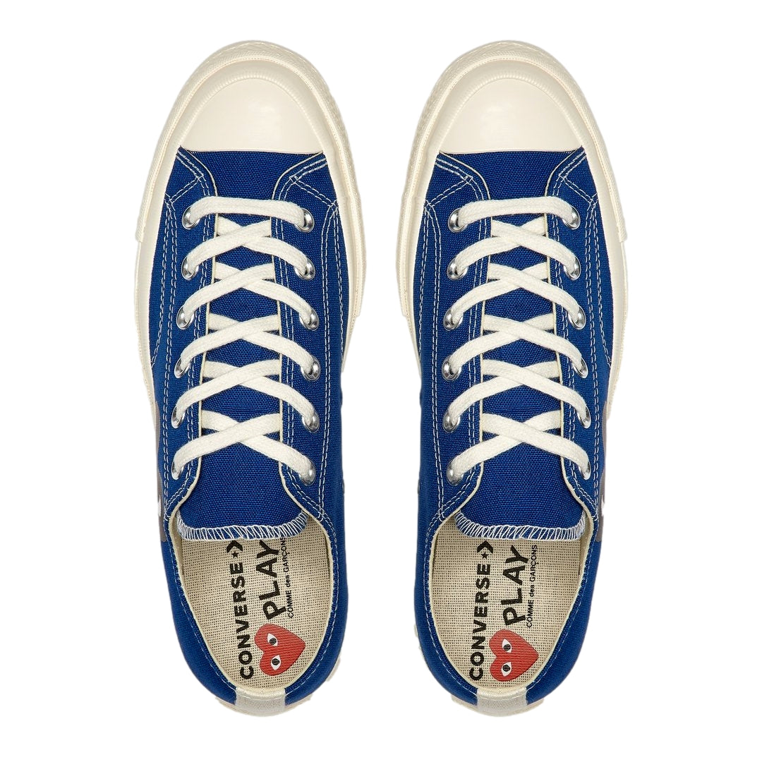 Blå Comme des Garcons Play x Converse lav-top sneakers med stor hjerte-trykk, vises med nærbilde av skoens design og materialer.