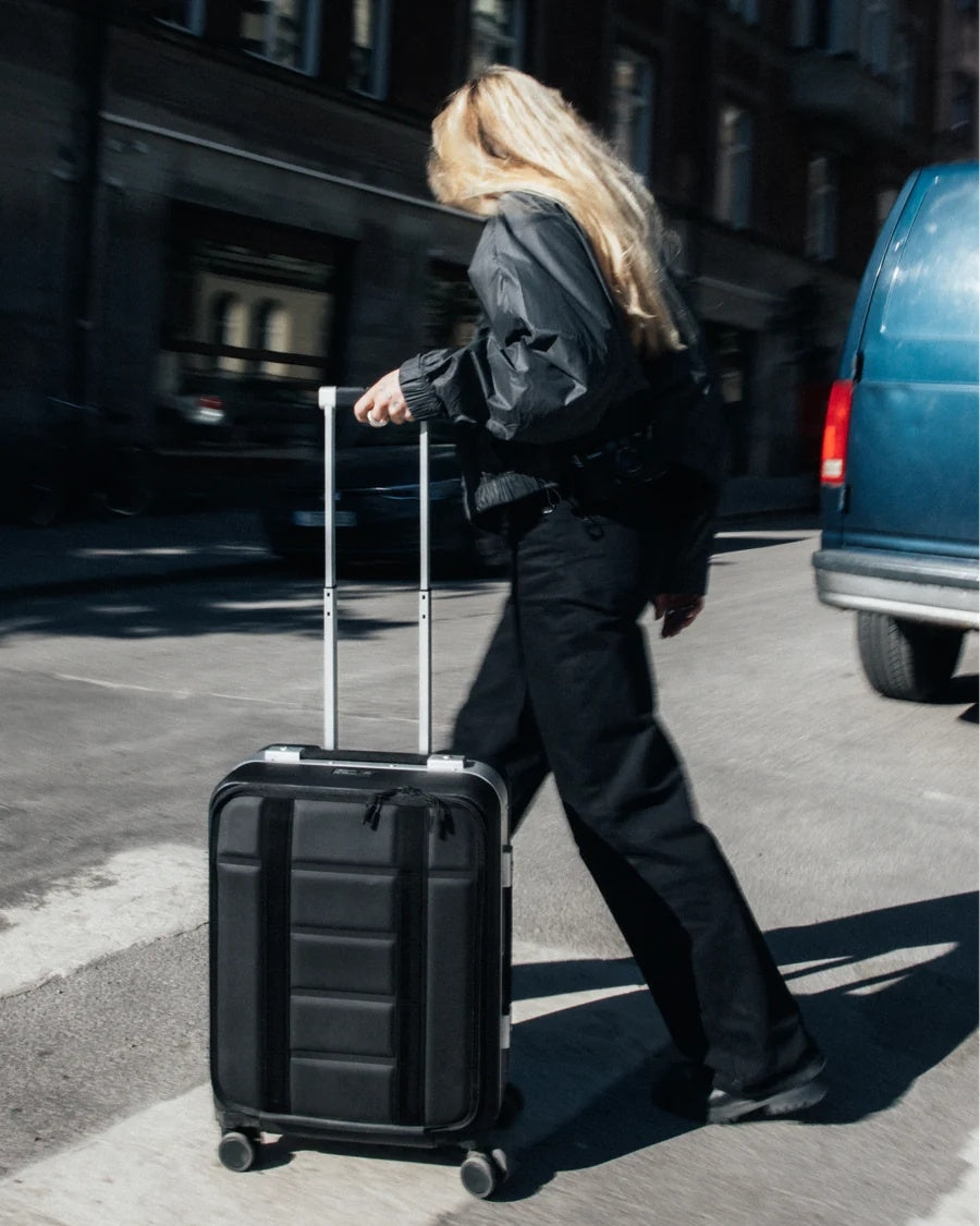 Db Ramverk Pro front-tilgang kabinkoffert i sølv med sort detalj, robust koffert med frontlomme og hjul for enkel reise.