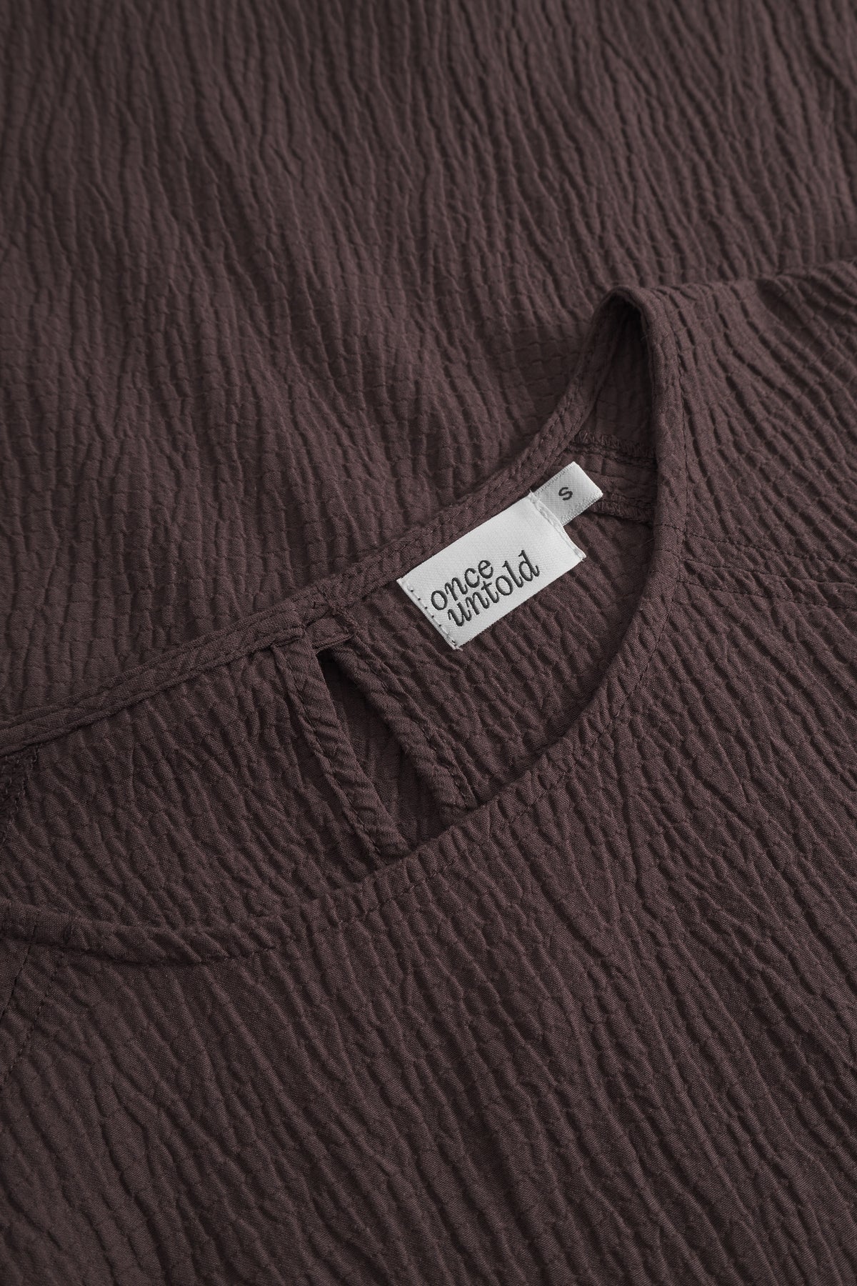 Brun Mercer skjorte fra Once Untold med knapper og klassisk design, vist med krage og langermede detaljer.