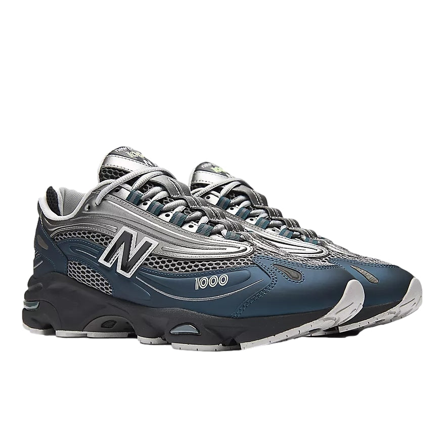 Blå og grå New Balance M1000S sko med komfortabel design, synlig i et nærbilde på skoens side og yttersåle.