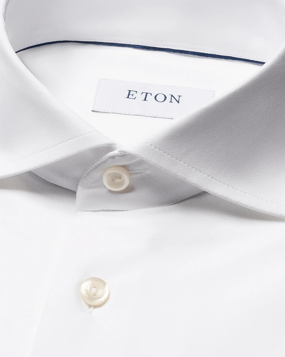 Hvit Eton semi-solid skjorte med fireveis stretch, vist på en modell med oppbrettede ermer og klassisk krage.