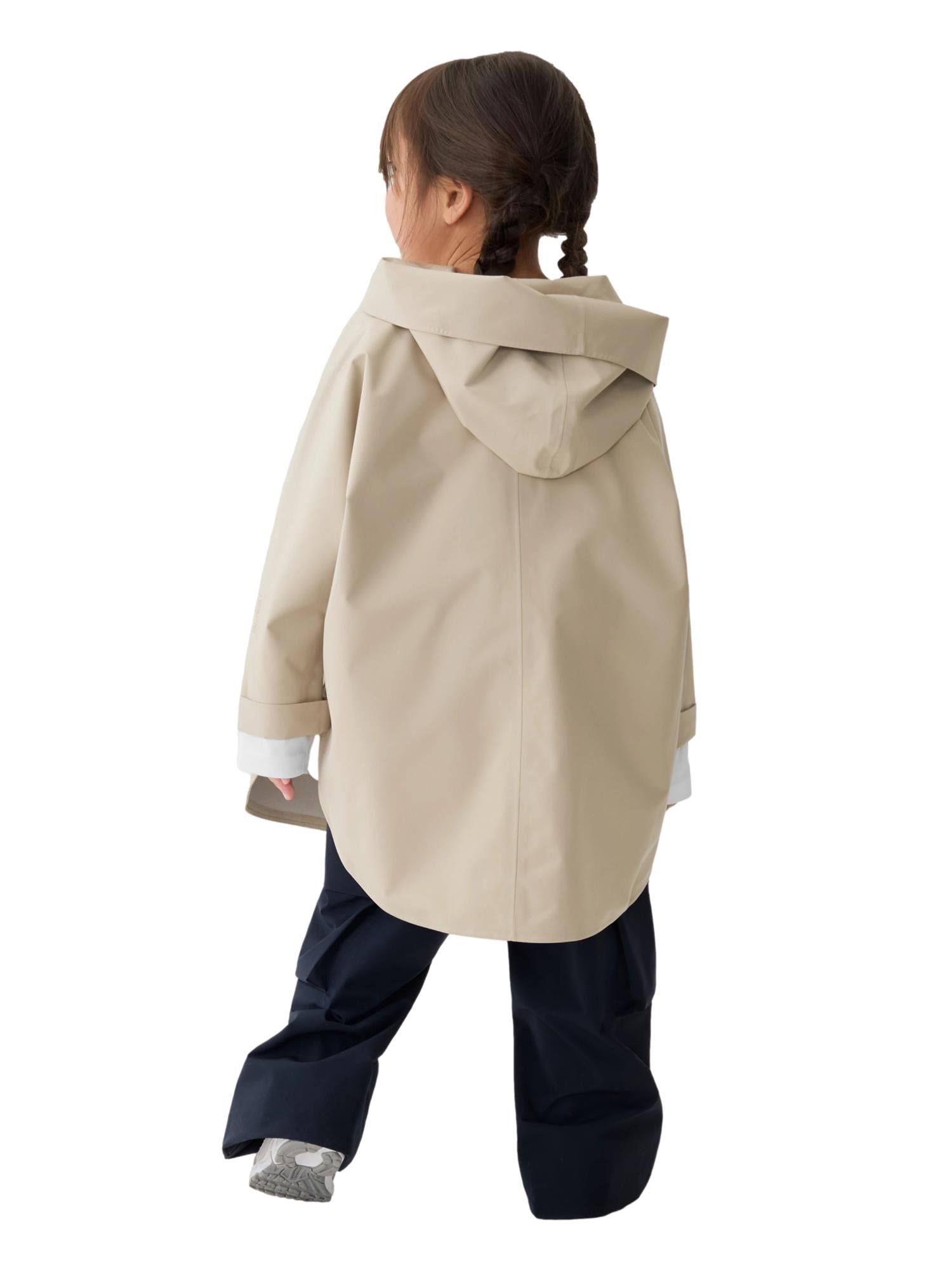 Blæst Bergen Mini Poncho beige jakke vist på modellen, myk og komfortabel med enkel design, perfekt for vår- og høstbruk.