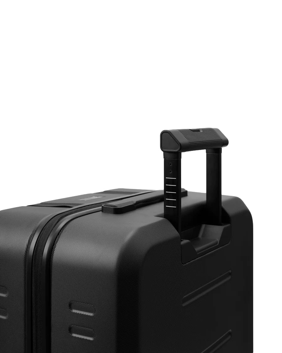 Sort Db Ramverk Check-In koffert i medium størrelse med glansfull overflate og fire hjul for enkel reise.