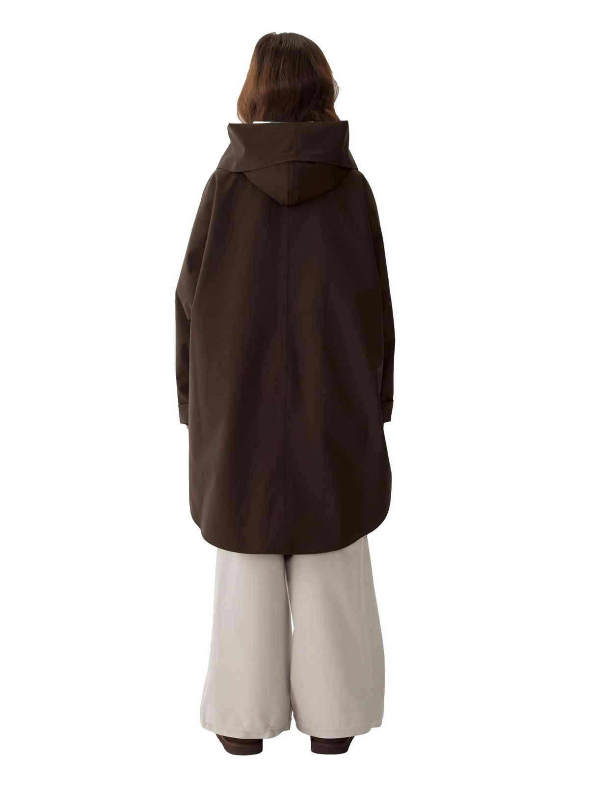 Blæst Bergen Mini Poncho Java jakke i brunt stoff, vises på modellen foran en nøytral bakgrunn.
