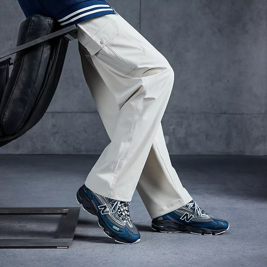 Blå og grå New Balance M1000S sko med sportslig design og komfortabel passform, vist fra siden.