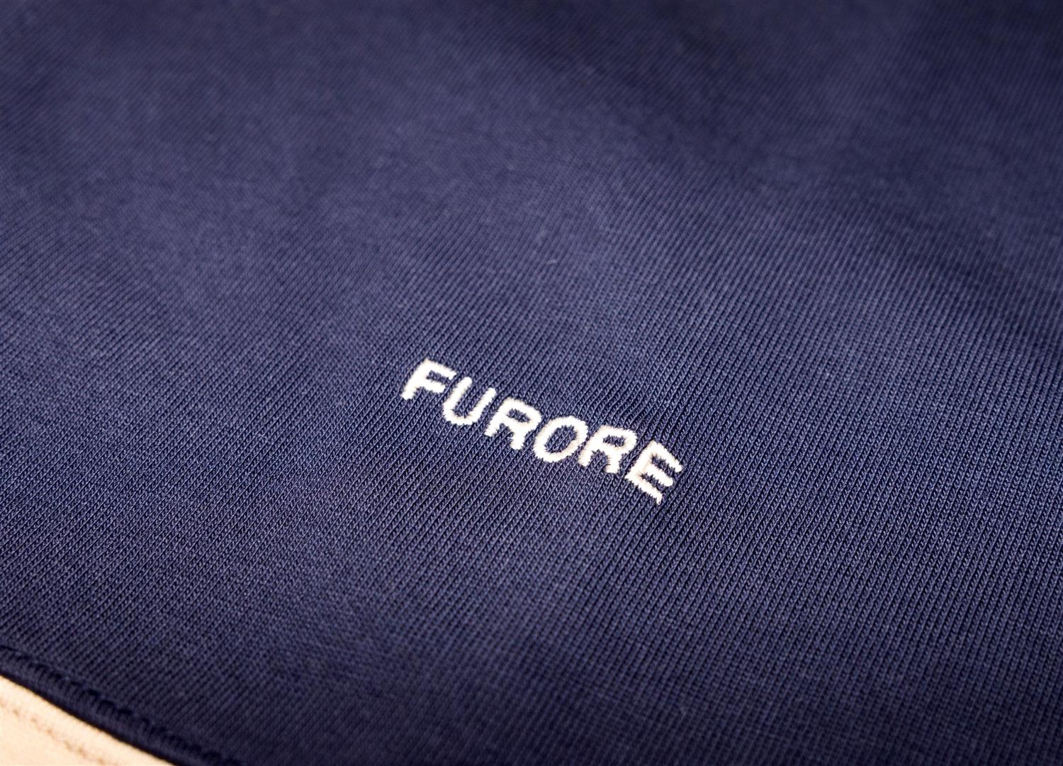 Furore William rugbygenser i blå og beige med logo og ribbestrikkede detaljer, vist på en modell.