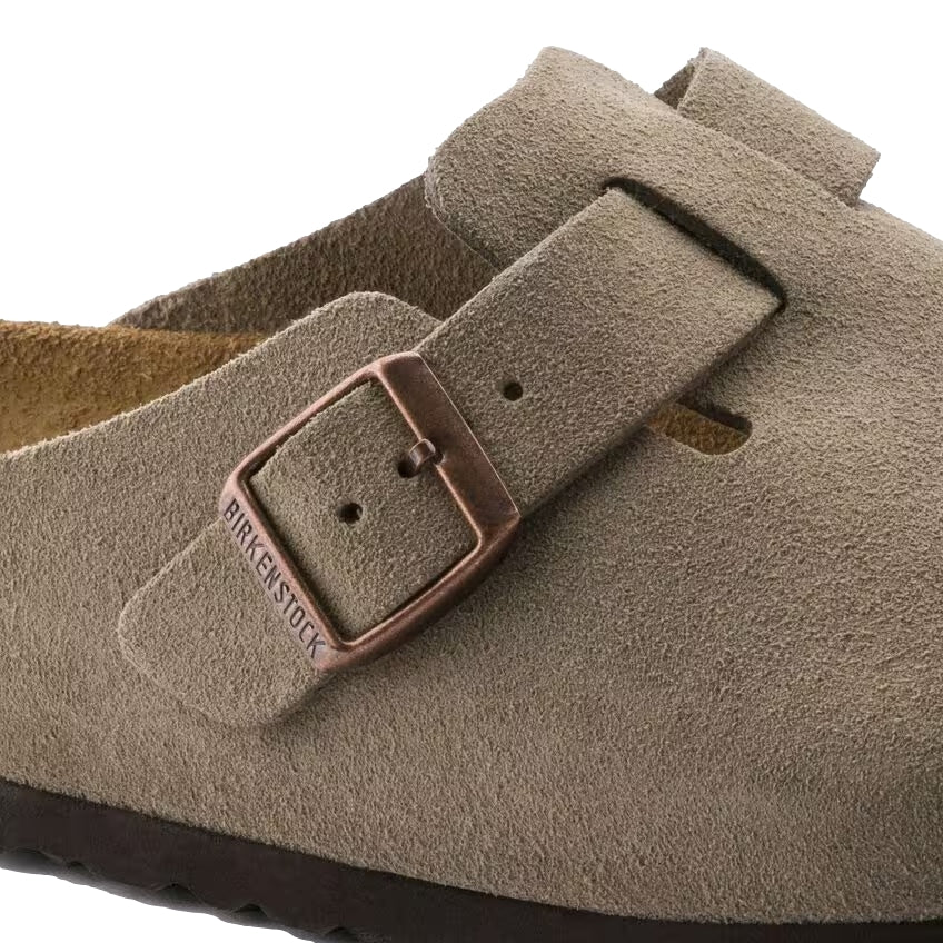 Birkenstock Boston suède sko i taupe med komfortabel design og justerbar rem, vist fra siden.