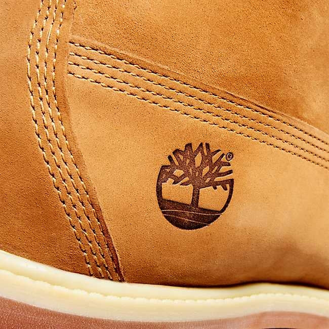 Tidløse Timberland 6-tommers premium støvler i gul skinn, vist fra siden med snøring og robuste såler.