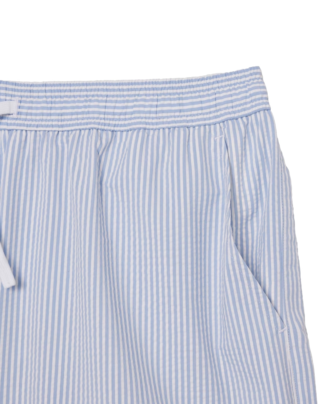 Lacoste badetøy, mid-length stripete svømmebokser med tekstur i hvitt og blått, foran på stranden.