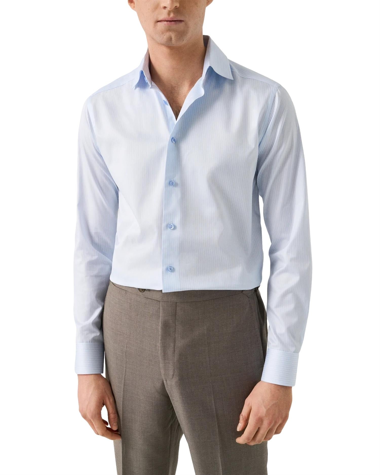Eton stripete signatur twill skjorte i lyseblå med blå og hvite striper, her vist i nærbilde av stoff og knapp.