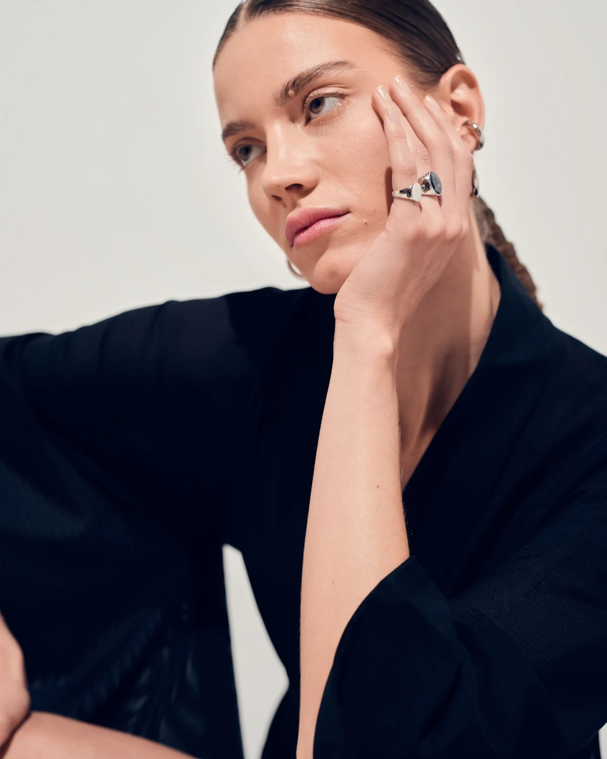 Sølv Tom Wood mini oval ring med elegant design, vist på fingeren, detaljert nærbilde av smykket.