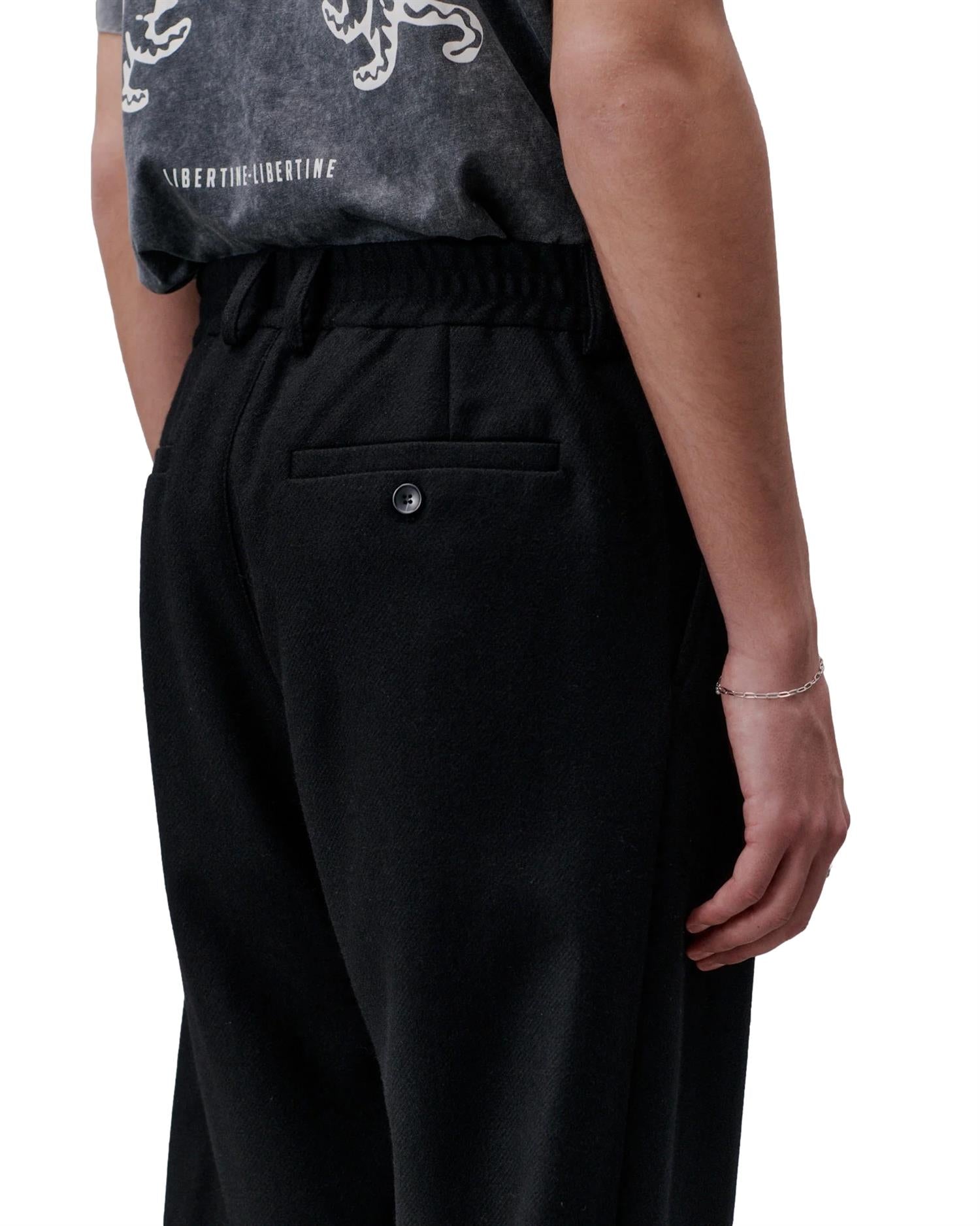Sort bukse fra Libertine Libertine med rett passform og mykt stoff, vist på modell.