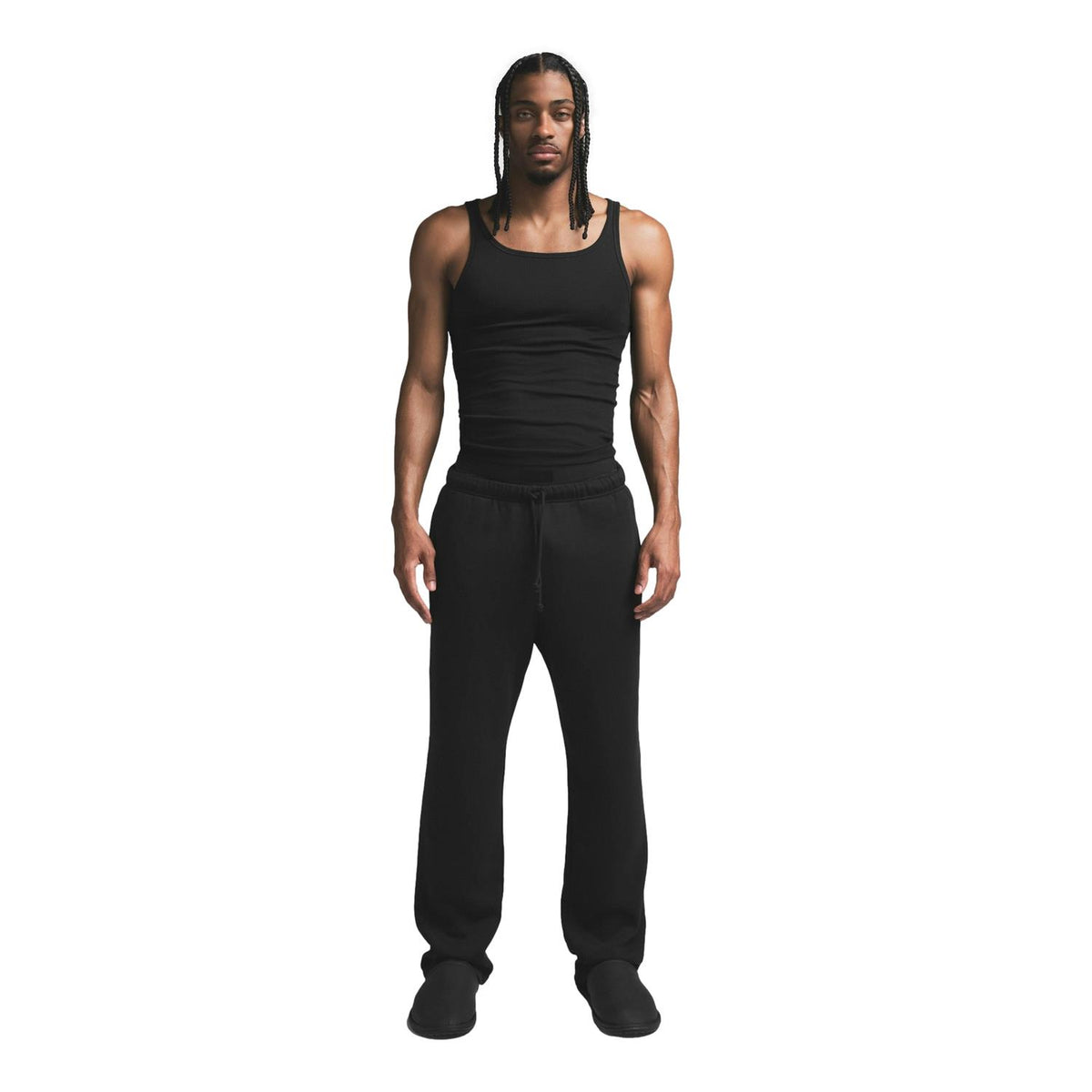 Svart SKIMS bomulls ribbet singlet, trepakning, vist på en modell, fokus på komfortabelt og elastisk stoff.