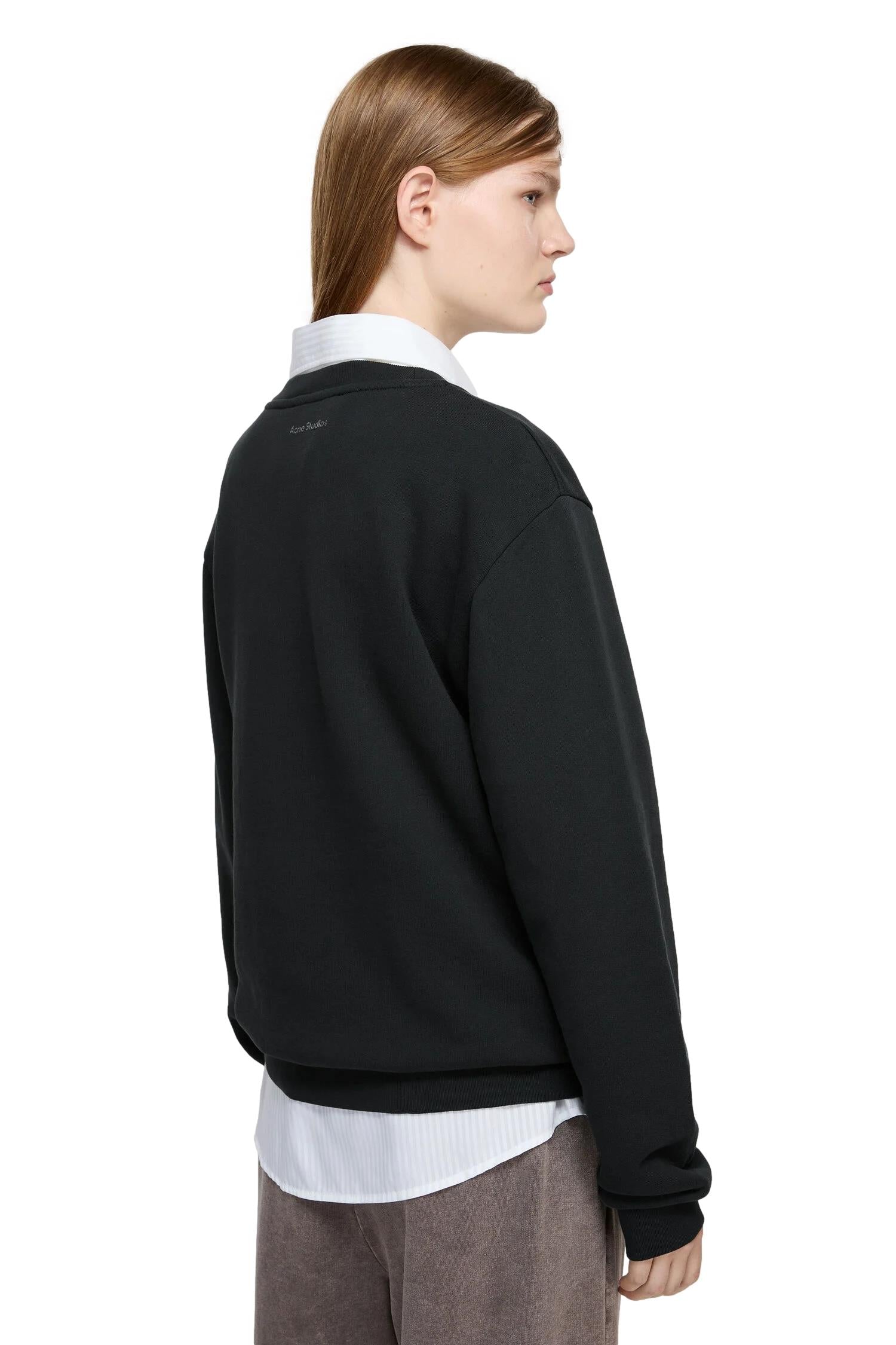Svart Acne fleece-genser med rund hals og ansiktsdesign, komfortabel og myk for avslappet antrekk.