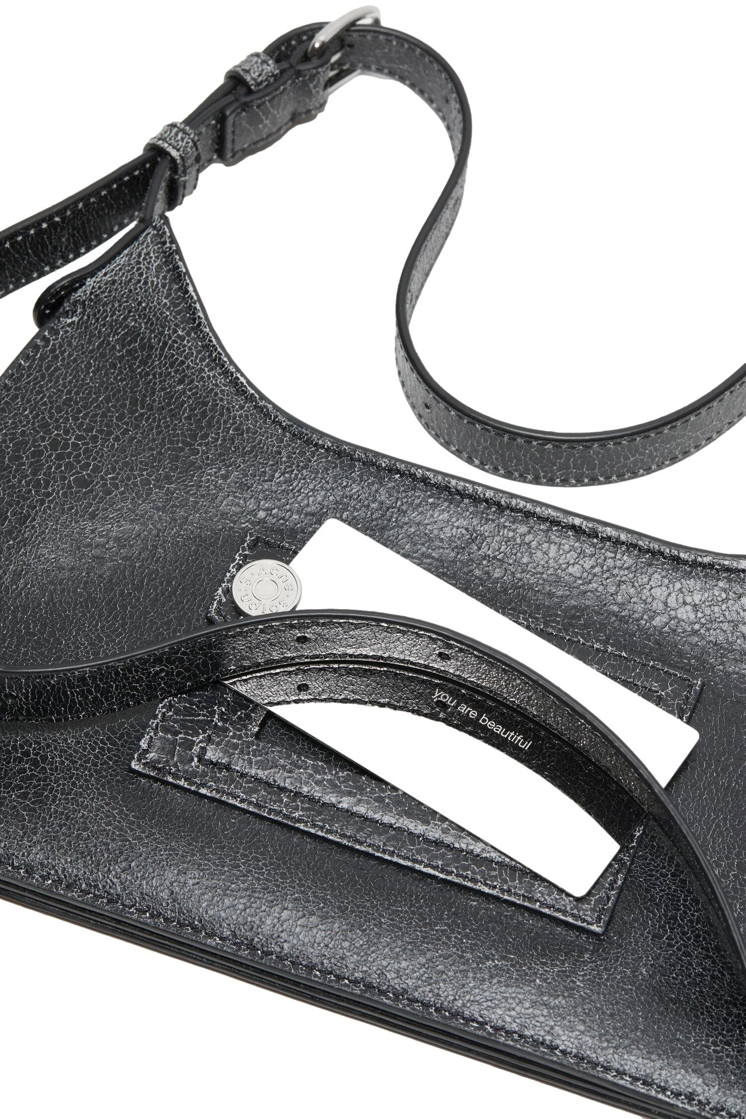 Sort Acne Platt Mini skulderveske med glatte overflater og justerbar skulderrem, liten og stilfull til daglig bruk.