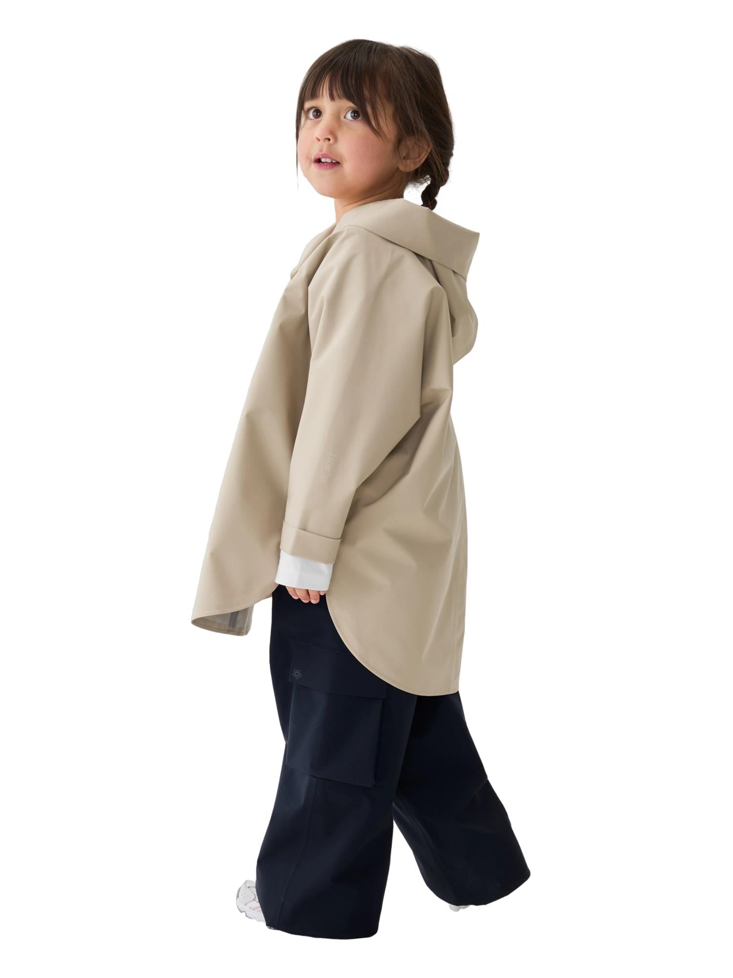 Blæst Bergen Mini Poncho beige jakke, lett og stilig med myk tekstur, designet for komfort og stil.