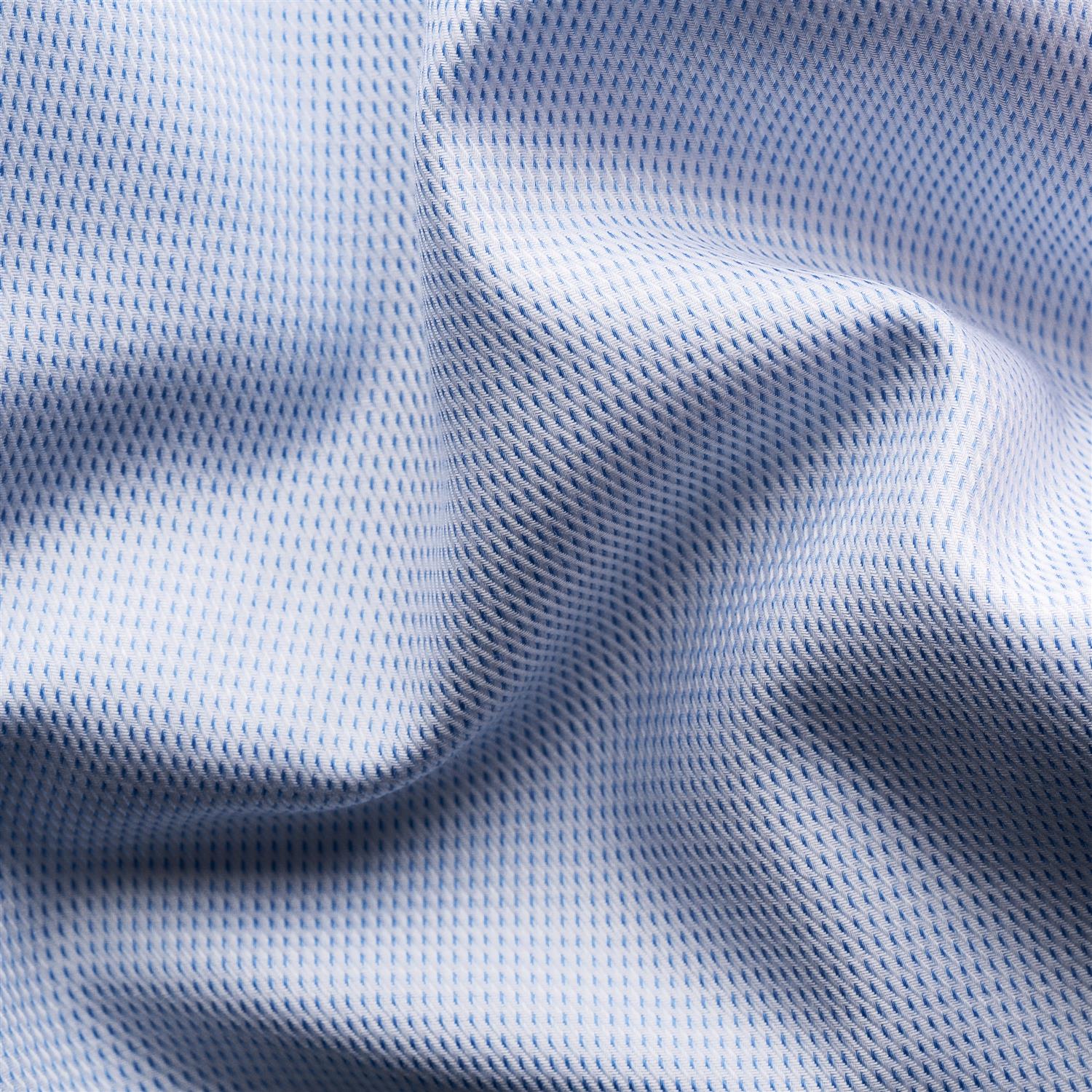 Lyseblå Eton skjorte i fin twill med klassisk krage og knappestolpe, vist foran på en modell.