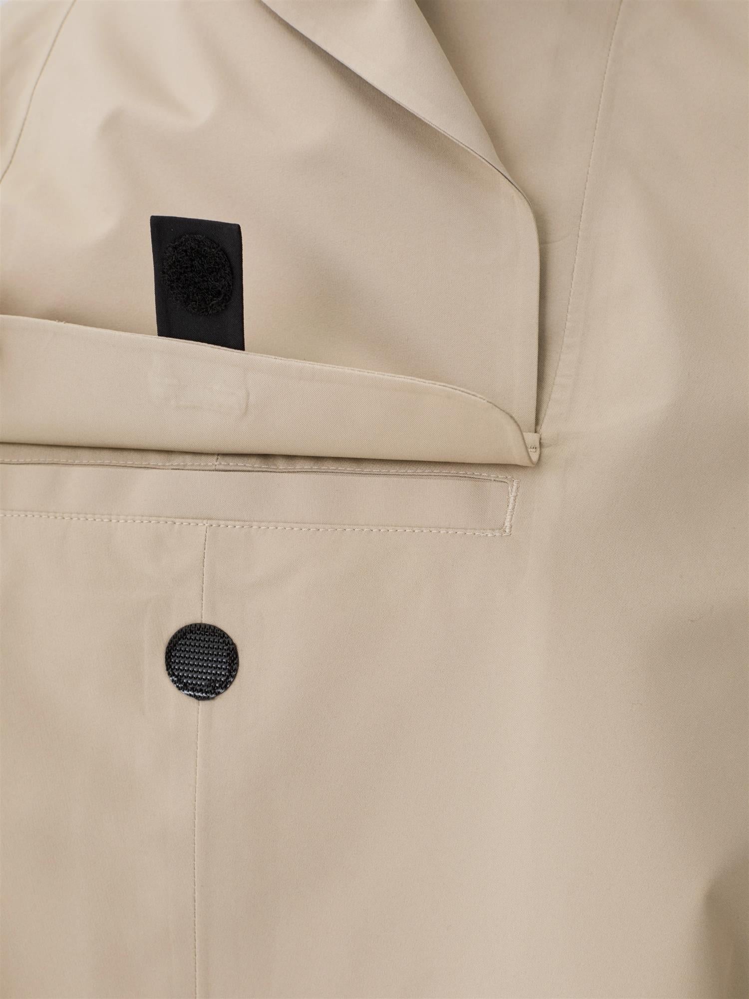 Blæst Bergen Mini Poncho beige jakke, myk og stilig med hette og dekorative sømmer, perfekt for vår og høst.