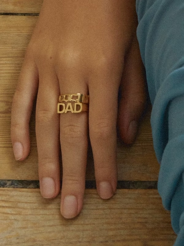 Maria Black Dad ring i gull, close-up av den elegante gullringen med minimalistisk design og Maria Black logo.