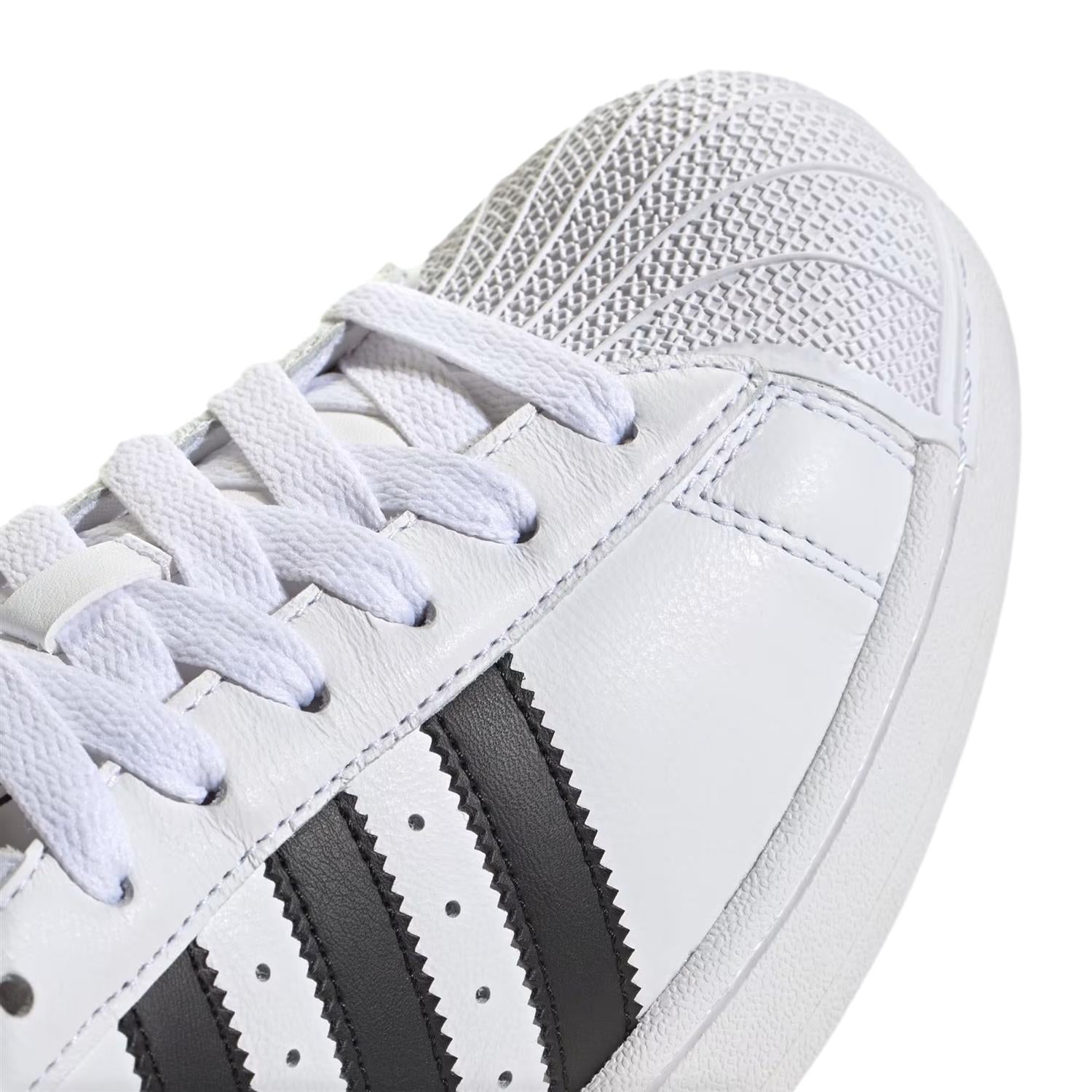 Hvite Adidas Superstar II sko med klassisk design og hvit skotupp, vist fra siden med synlige lissesystemer.