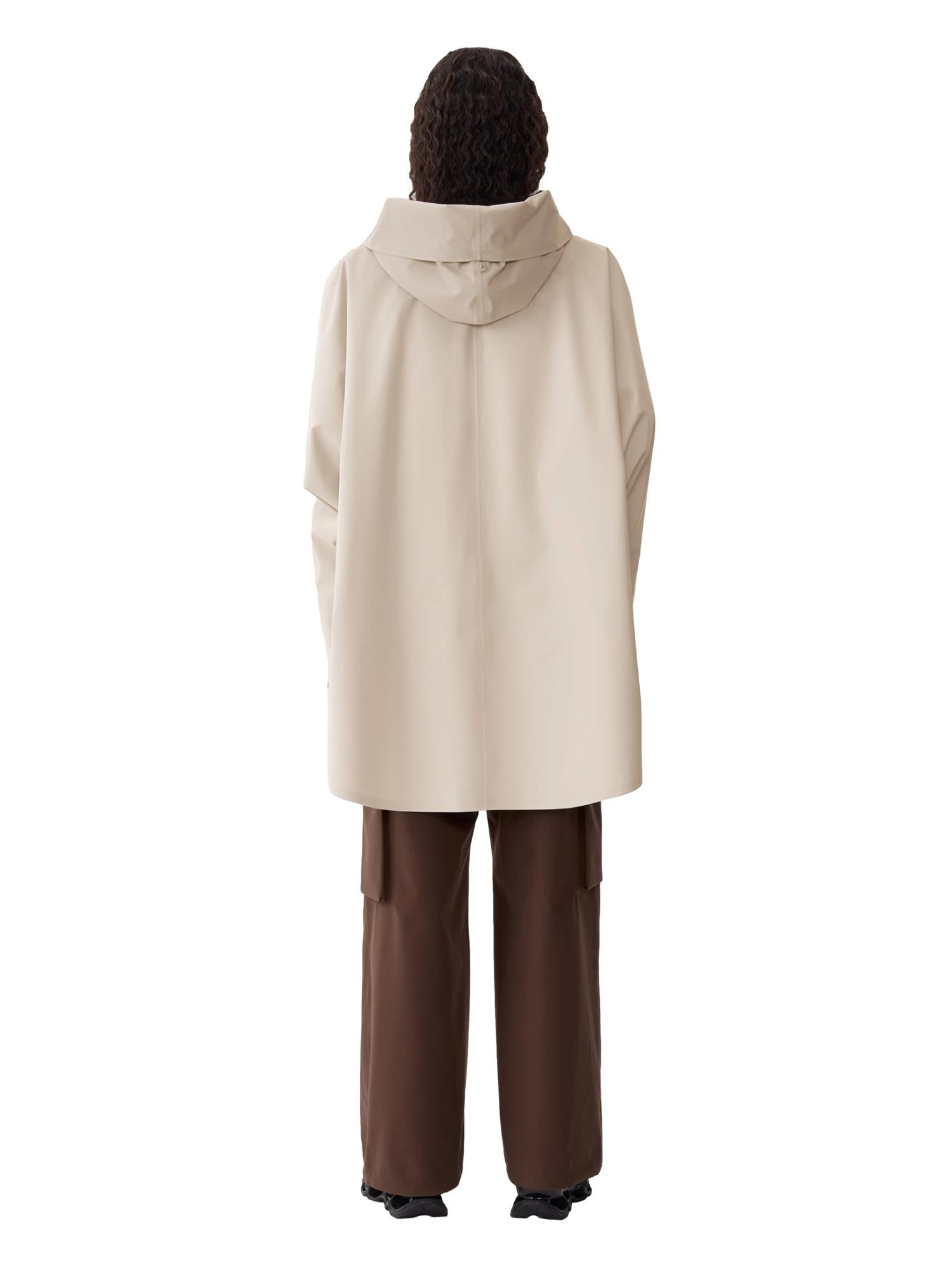Blæst Bergen beige ponchojakke med myk tekstur og løs passform, vist på modell foran nøytral bakgrunn.