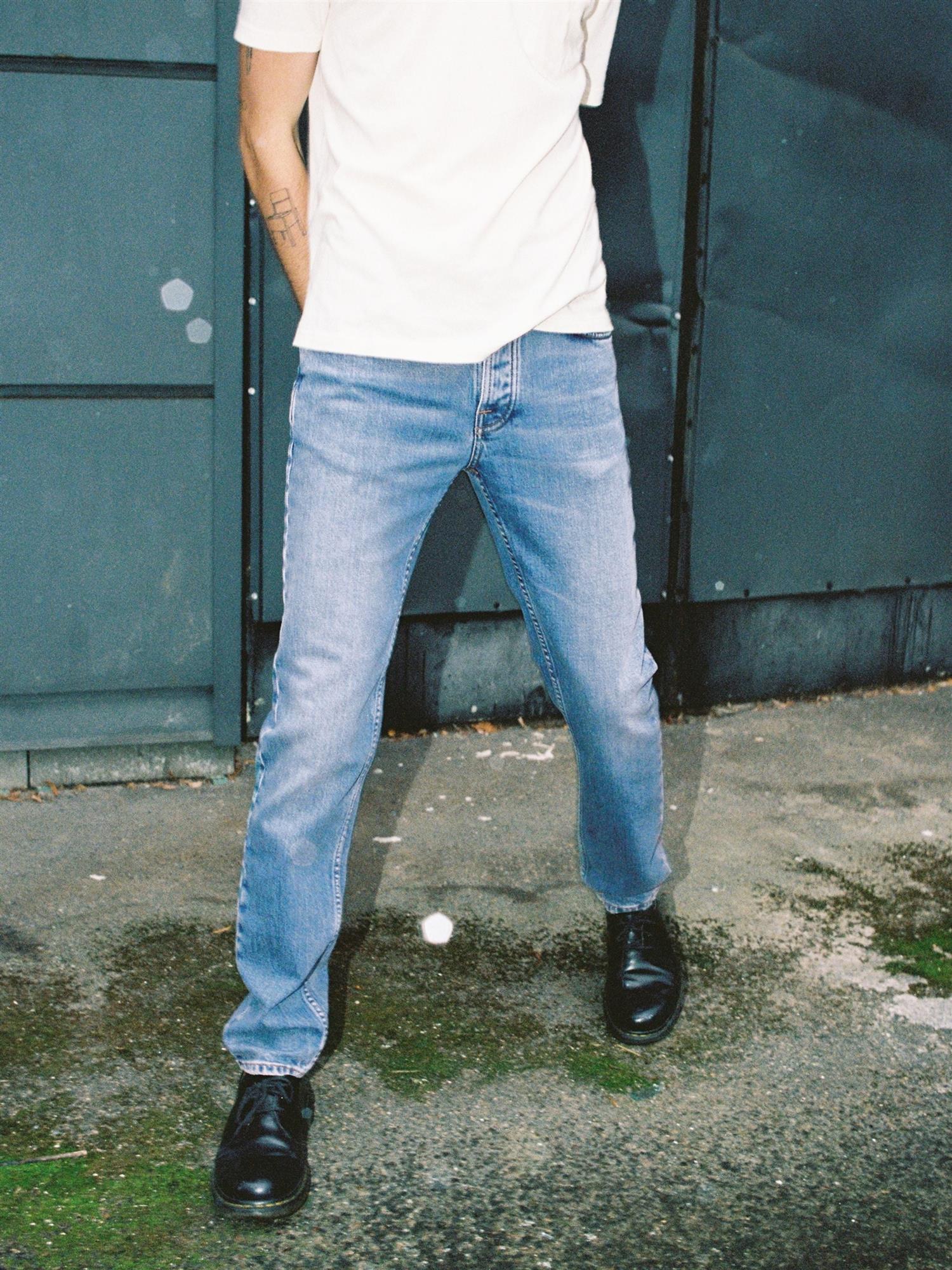 Nudie Jeans Solid Ollie vintage blå jeans med slitte detaljer og klassisk snitt, vises på bildet.