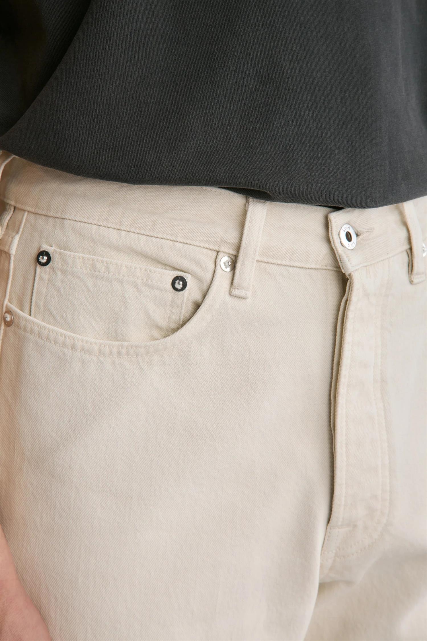 Livid Barnes Fade Bone jeans i off-white farge, med slitte detaljer og klassisk denimdesign, vist på et modell.