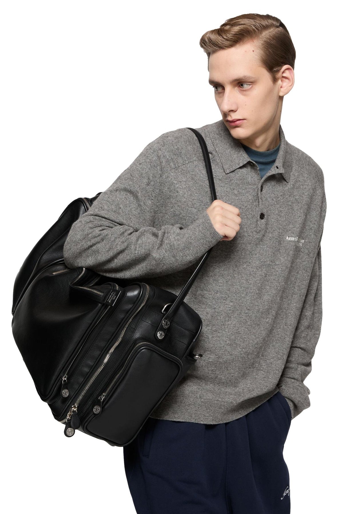 Grå Acne Wool Knit Polo-genser med rund hals og lang erm, vist på modell foran nøytral bakgrunn.