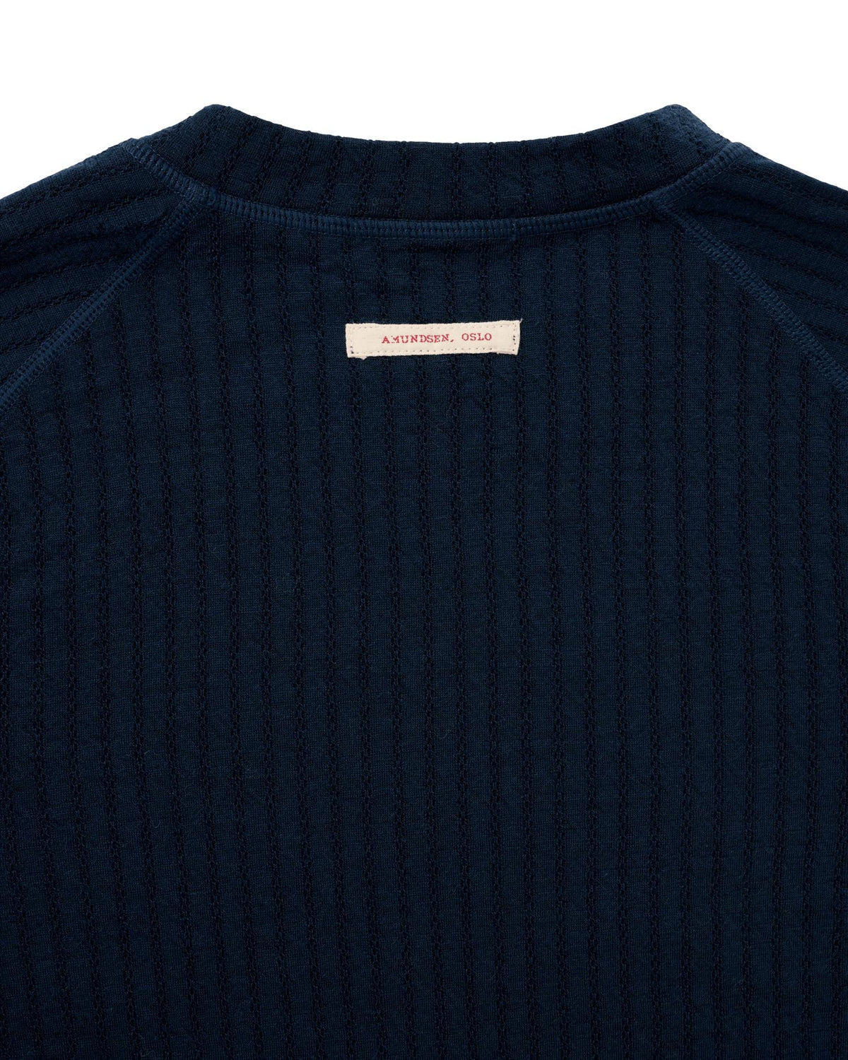 Amundsen Hero's Hide ullundertøy i mørkeblå, crew neck av varm, myk ull til herre, synlig på bildet.