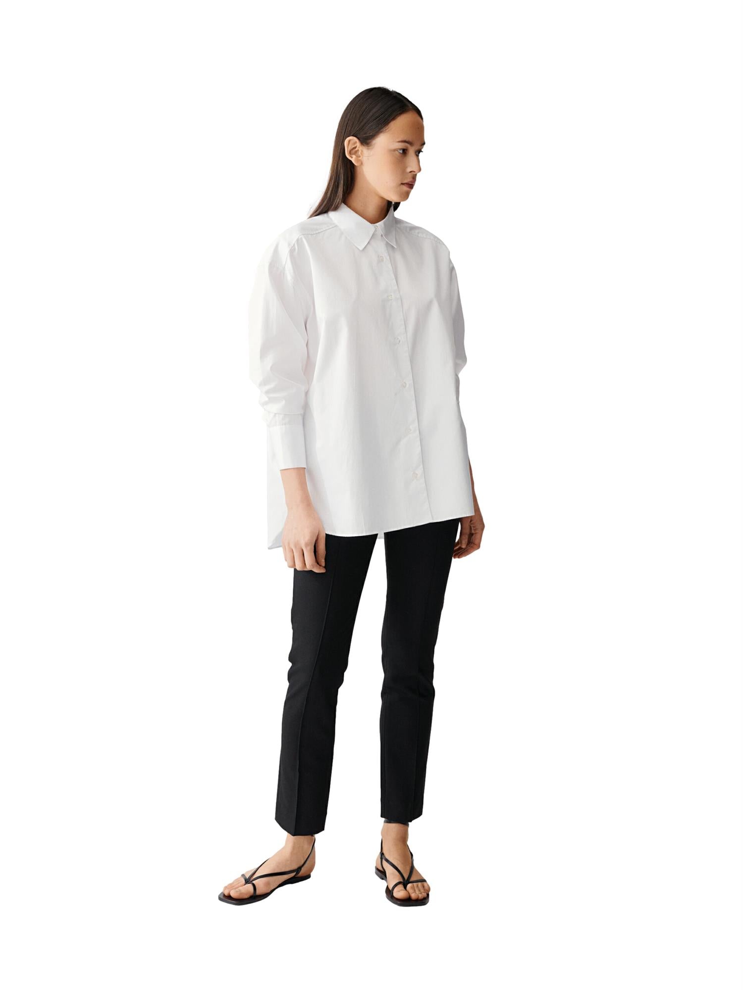 Hvit Julie Josephine Albertine Skjorte med krage og lange ermer, laget av mykt stoff, vist på modell.