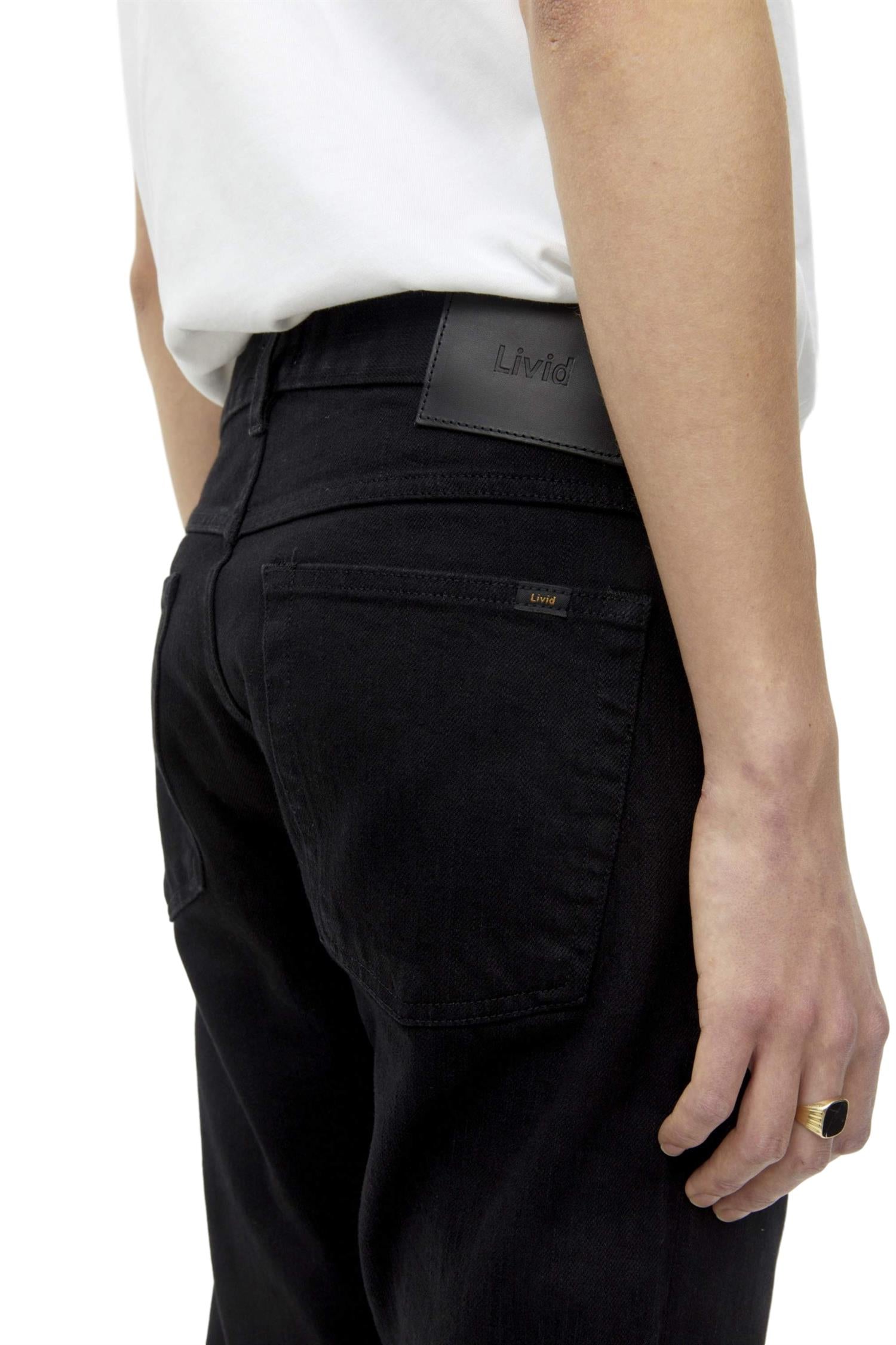 Sort Livid Jone jeans for menn, vises med lommer og slitte detaljer, avslappet passform og klassisk jeansdesign.