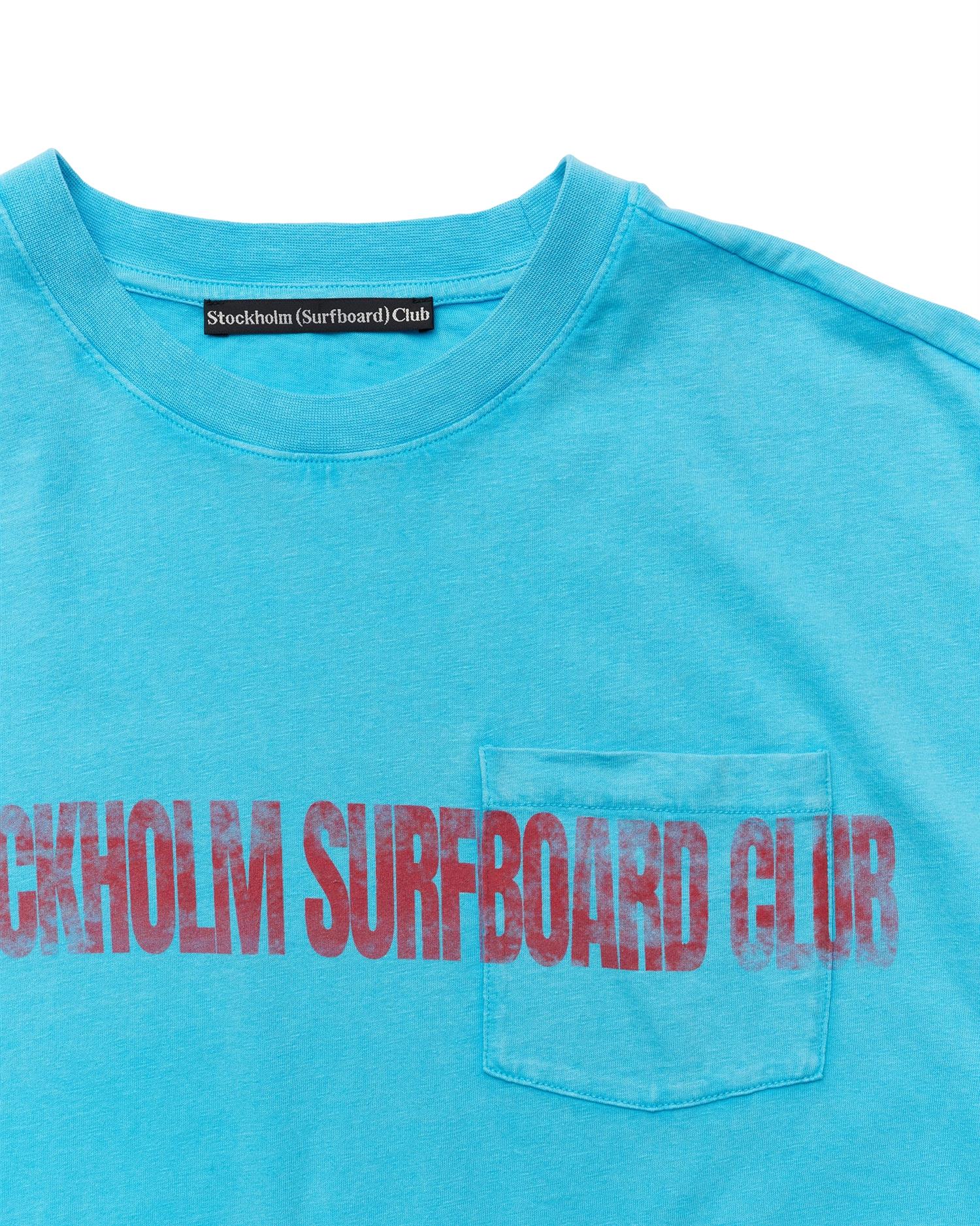 Turkis Stockholm Surfboard Club Pocket T-skjorte med liv-Design, myk bomulls-kvalitet, for surfing og avslapning.