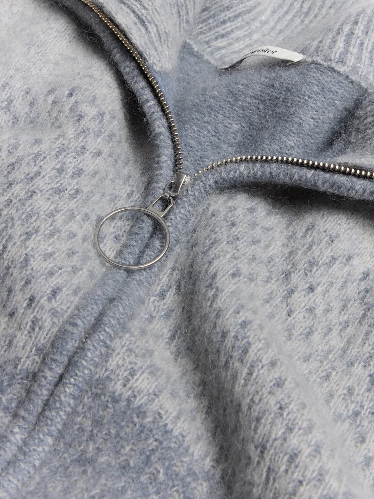 Holzweiler Tine Cardigan i lyseblå og gråblå med myk, strikket tekstur, vist på en modell foran en nøytral bakgrunn.