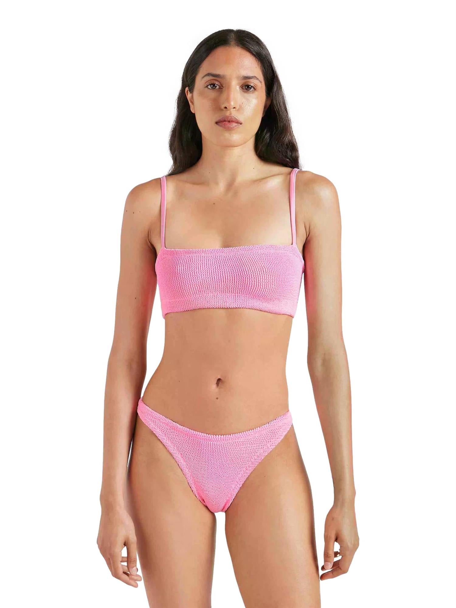 Hunza G Gigi bikini i rosa med bobleeffekt, vises på modell i solskinn, laget av stretchy, komfortabelt materiale.