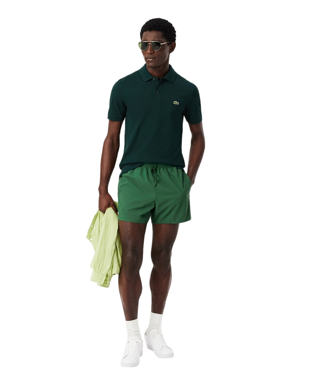 Lacoste raske tørkebadshorts i grønn med logo, designet for svømming og sommeraktiviteter, vist på modell.