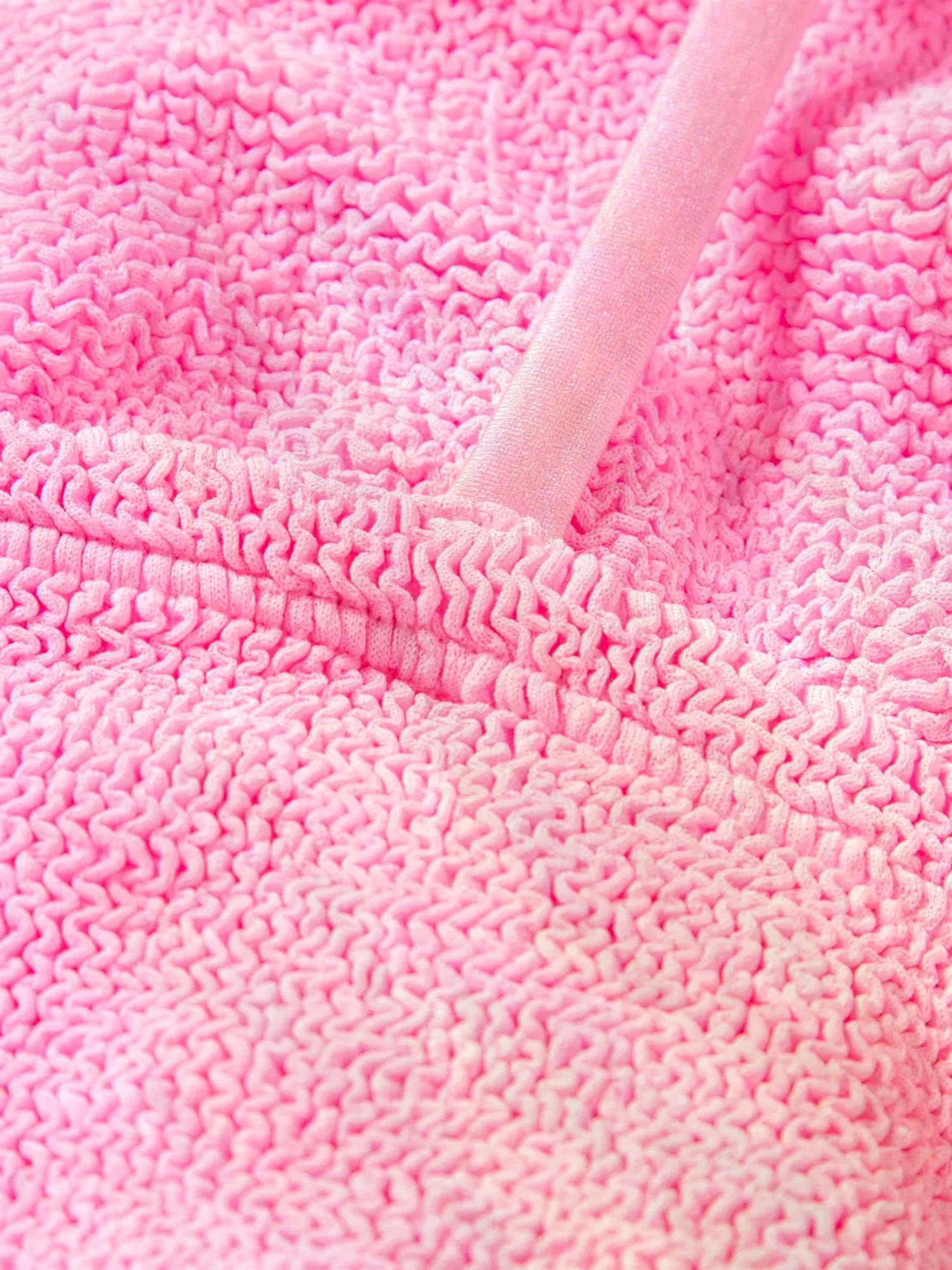 Hunza G Gigi rosa bikini med bubblegumfarge, myk og elastisk, vist på en modell i et solrikt utendørs miljø.