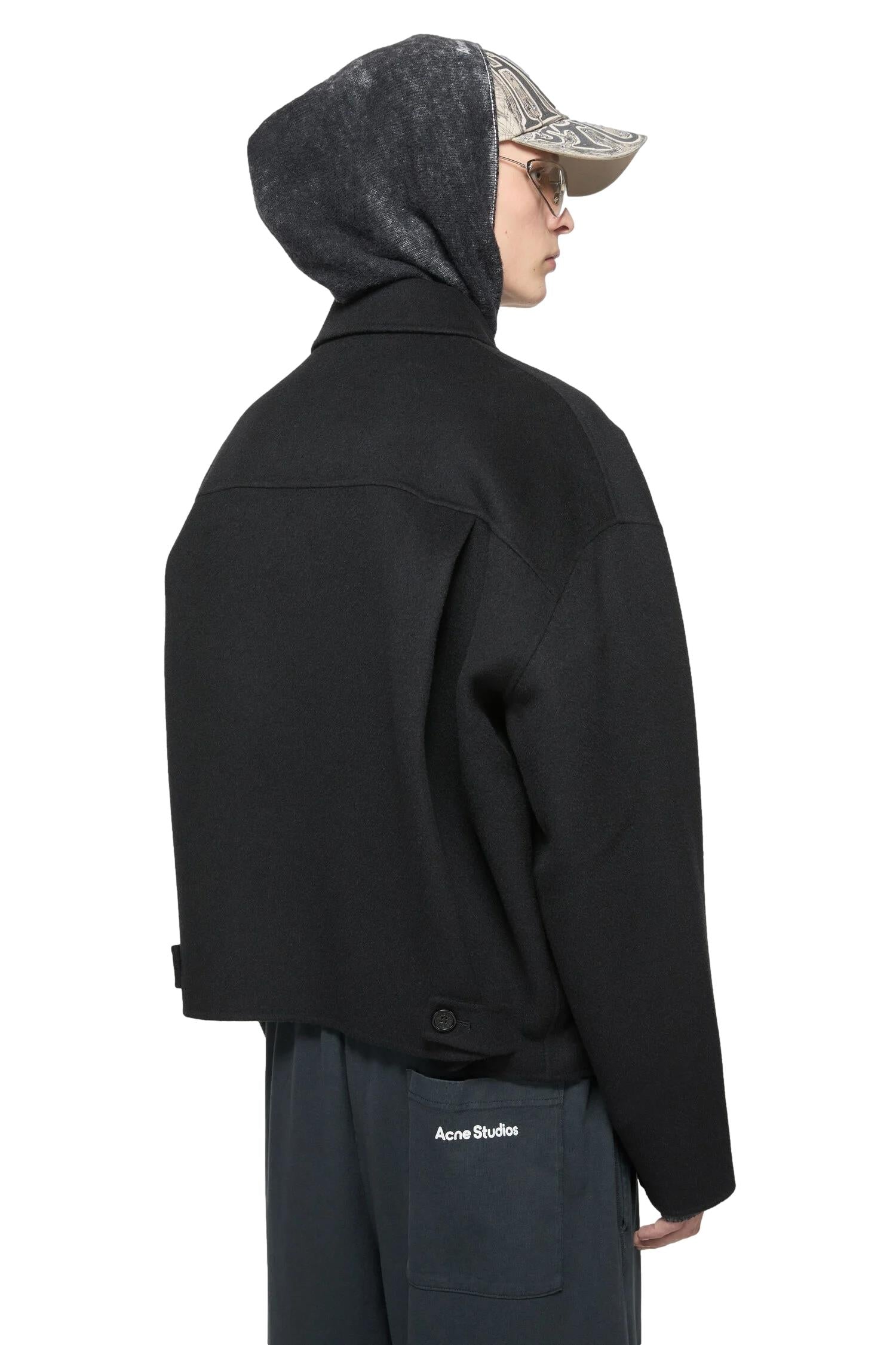 Sort Acne Wool Zipper Jakke, en stilfull og varm jakke med glidelås, vist på en modell mot en nøytral bakgrunn.