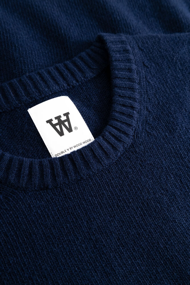 Blå Wood Wood WW Tal Crew Neck genser med rund hals og myk bomullsstoff, vist på modell.