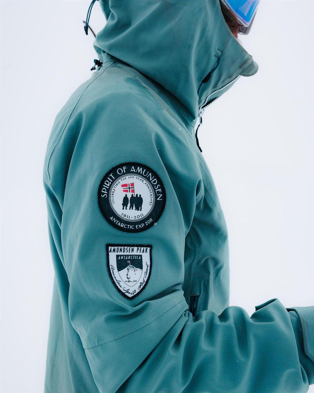 Amundsen Peak Jacket herre i stormy blue med turkisfarge, utendørsjakke med vannavstøtende materiale og justerbar hette.