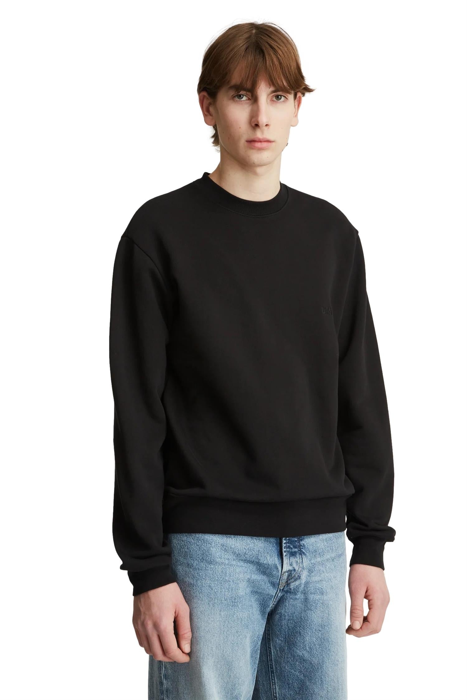 Livid Palmer svart genser med rund hals og lange ermer, avslappet passform, på en modell.