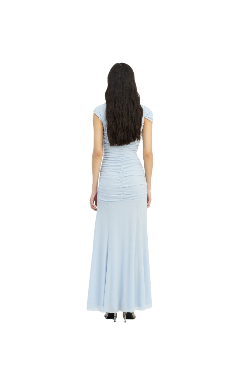 Lys blå ROTATE Maxi asymmetrisk kjole med elegant design og flytende stoff, vist på modell.